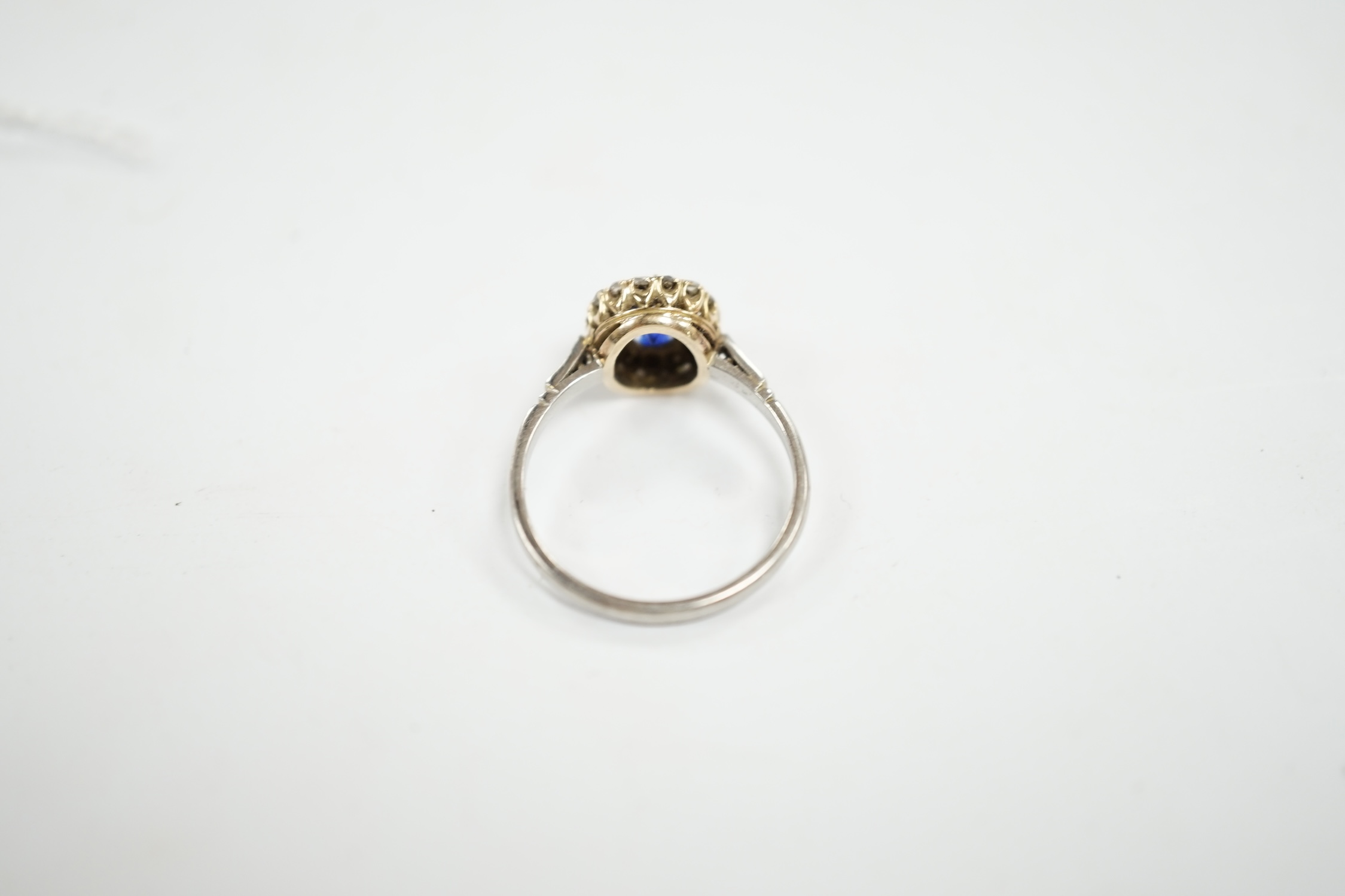 An early 20th century white metal (stamped plat), sapphire and diamond set cluster ring, size O, gross weight 3.6 grams. Condition - poor (two stones missing)